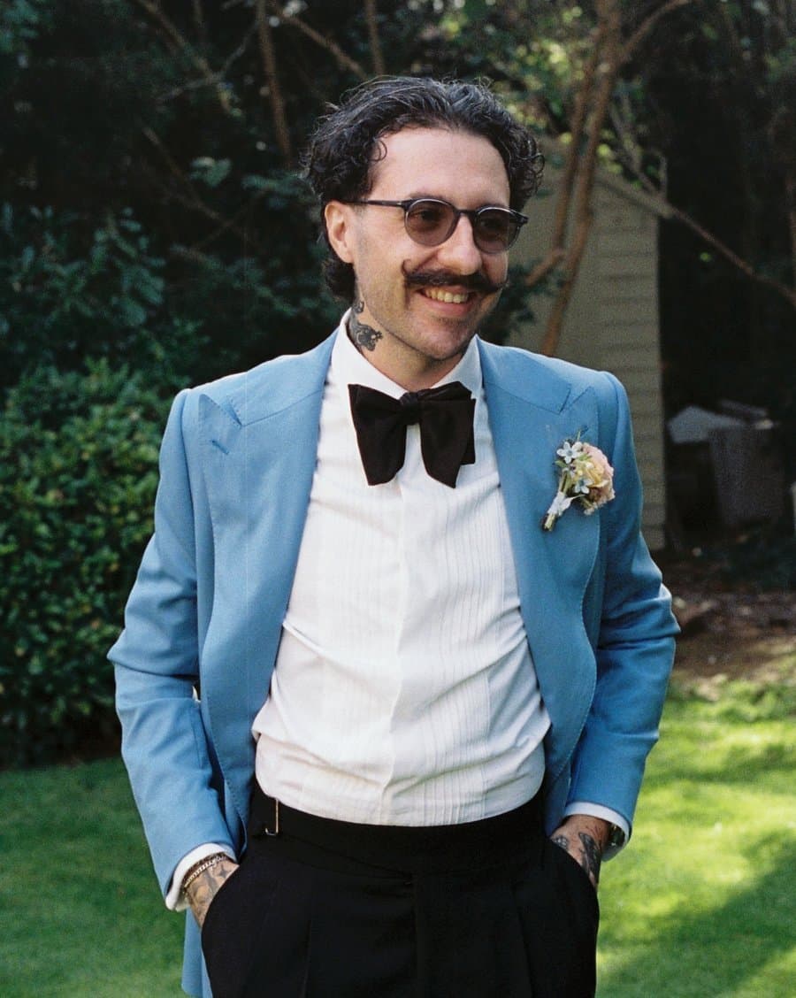 Curtis, smiling, in a blue jacket and bow tie
